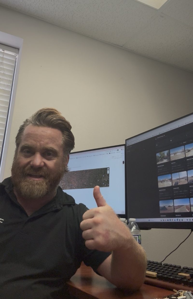 JR Ferguson at a desk with two monitors in the SystemX office, giving a thumbs up